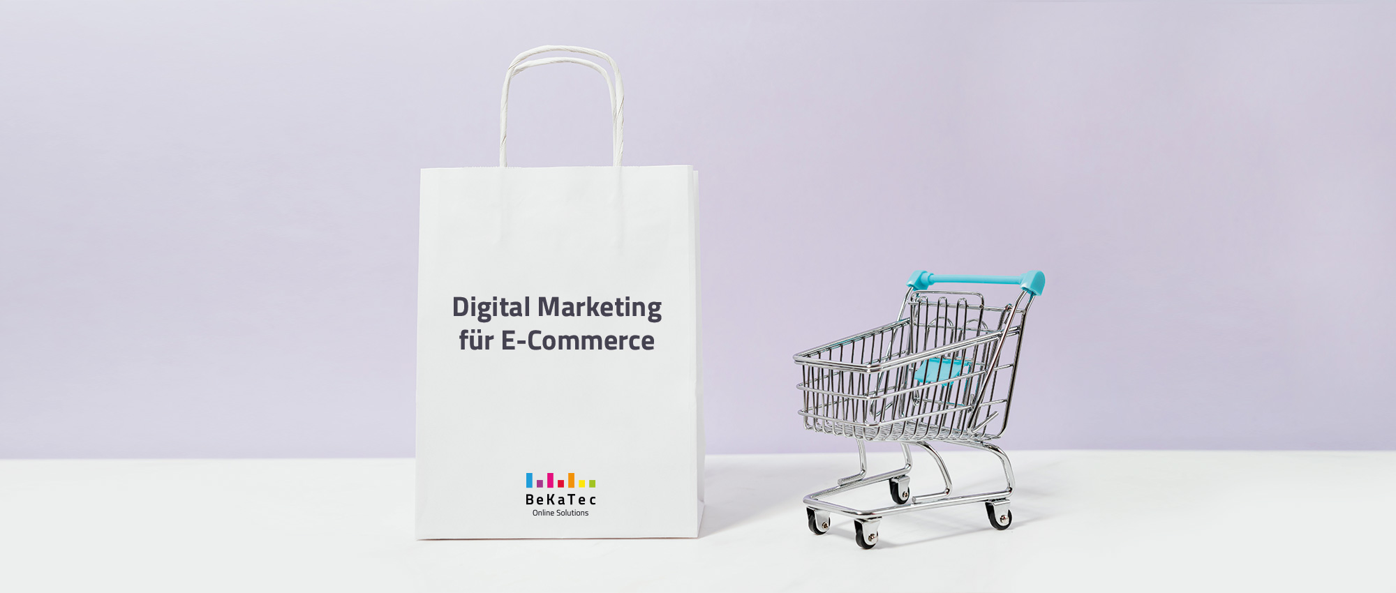 Ein Einkaufswagen mit türkisem Griff und Kindersitz steht neben einer riesigen, weißen, mit Digital Marketing für E-Commerce über dem Bekatec Regenbogenbalken Logo beschrifteten Papiertüte.